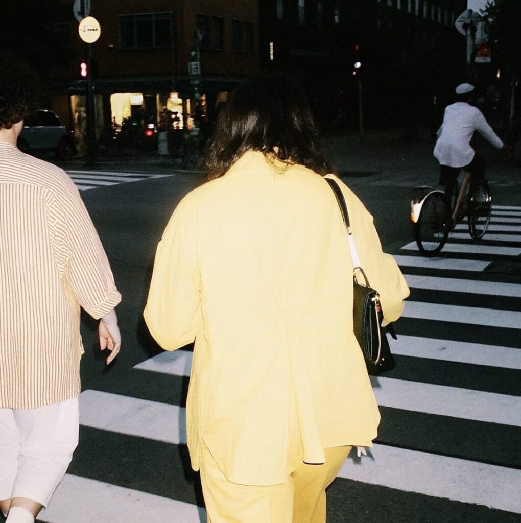 黄色い服を着た女性が横断歩道を渡る